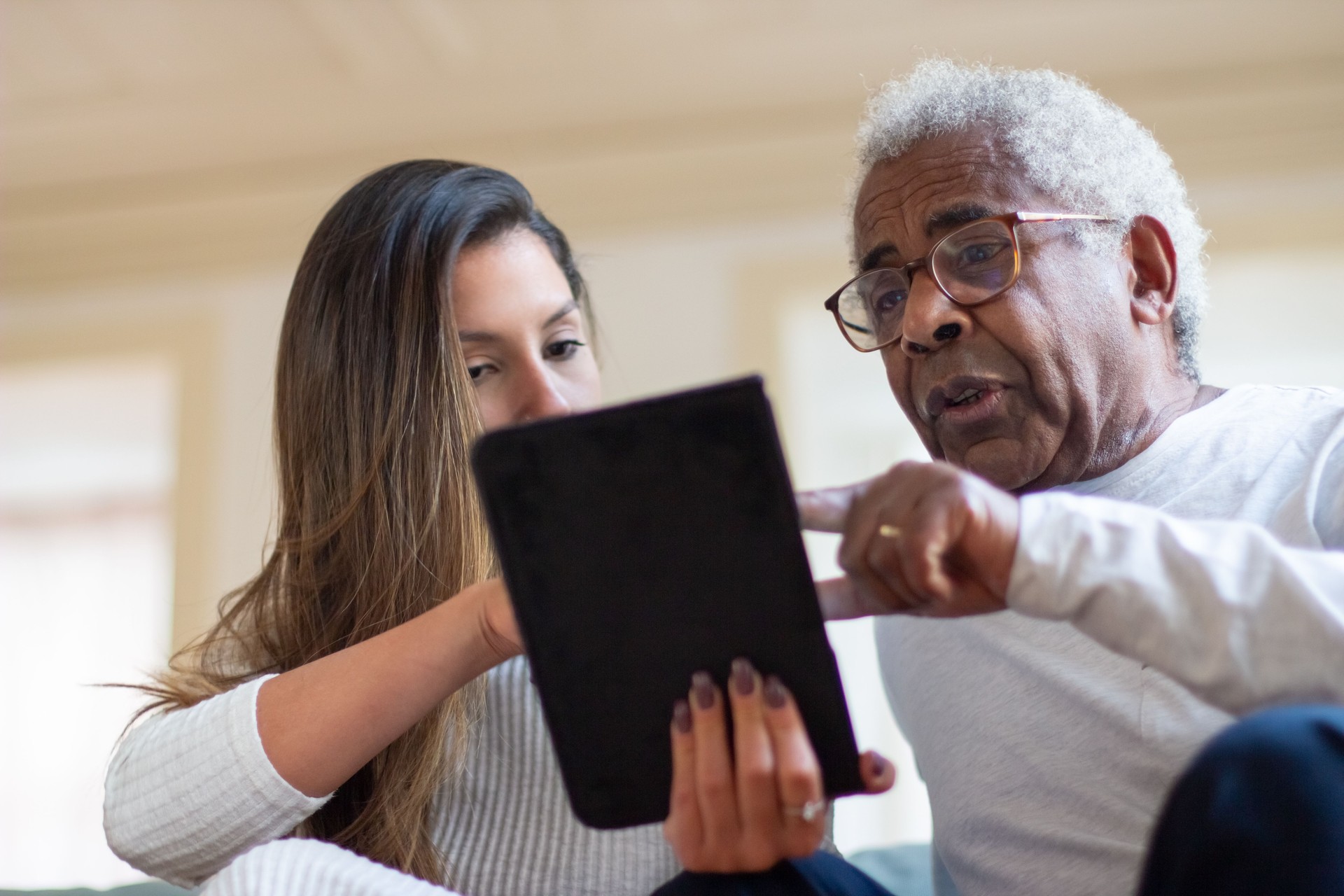 Close-up of aged man and daughter with digital tablet